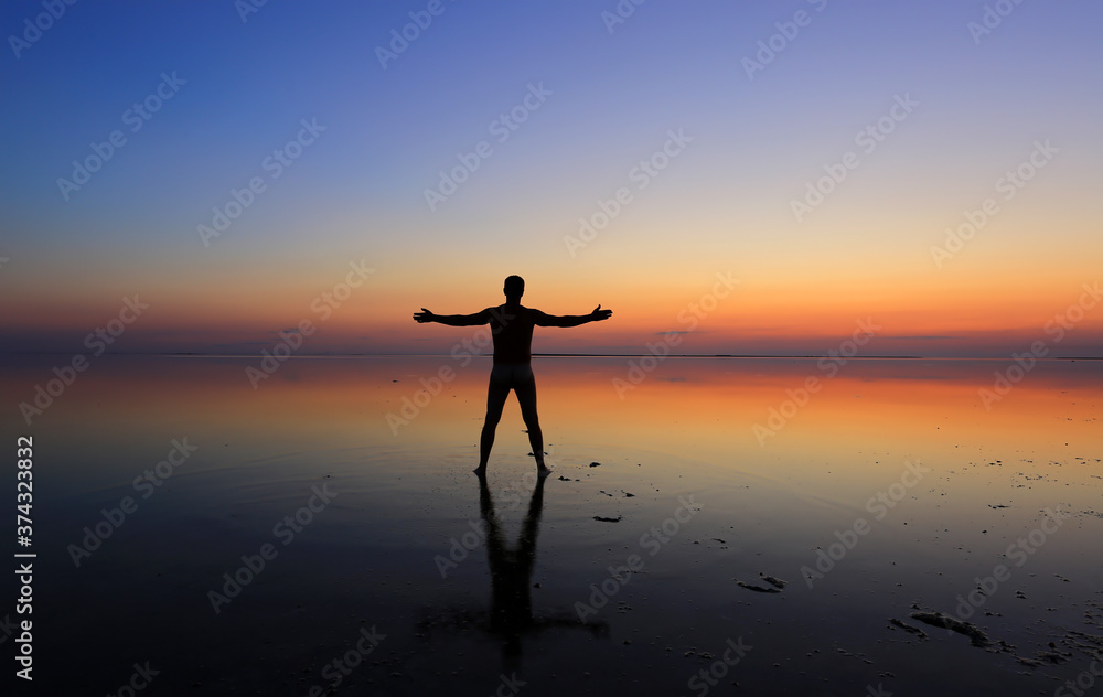 Silhouettes of a man on sunset background