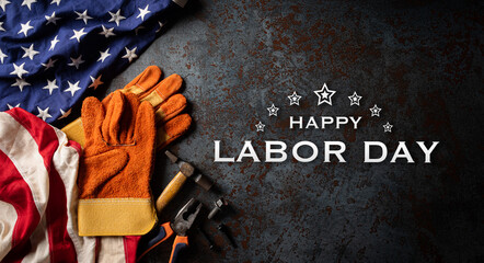 Happy Labor day concept. American flag with different construction tools on dark stone background, with copy space for text.
