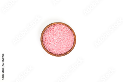 Pink salt in scoop and a wooden bowl isolated on white background. selective focus or blurry.