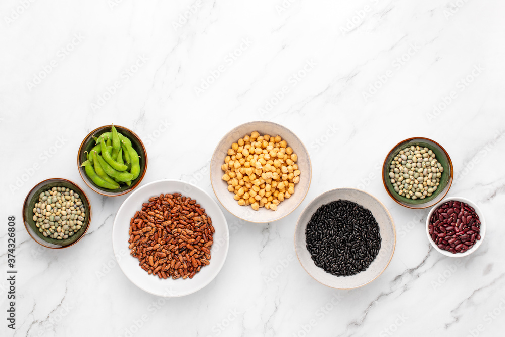Various kind of legumes in bowls standing on a marble kitchen table Various kind of legumes in bowls standing on a marble kitchen table