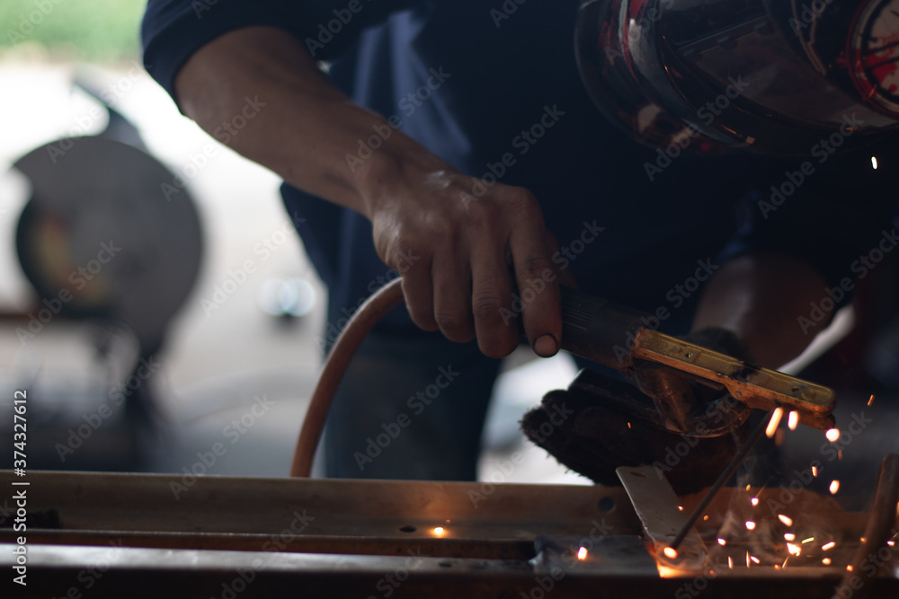 Worker,welding in a car factory with sparks, manufacturing, industry Worker,welding in a car factory with sparks, manufacturing, industry