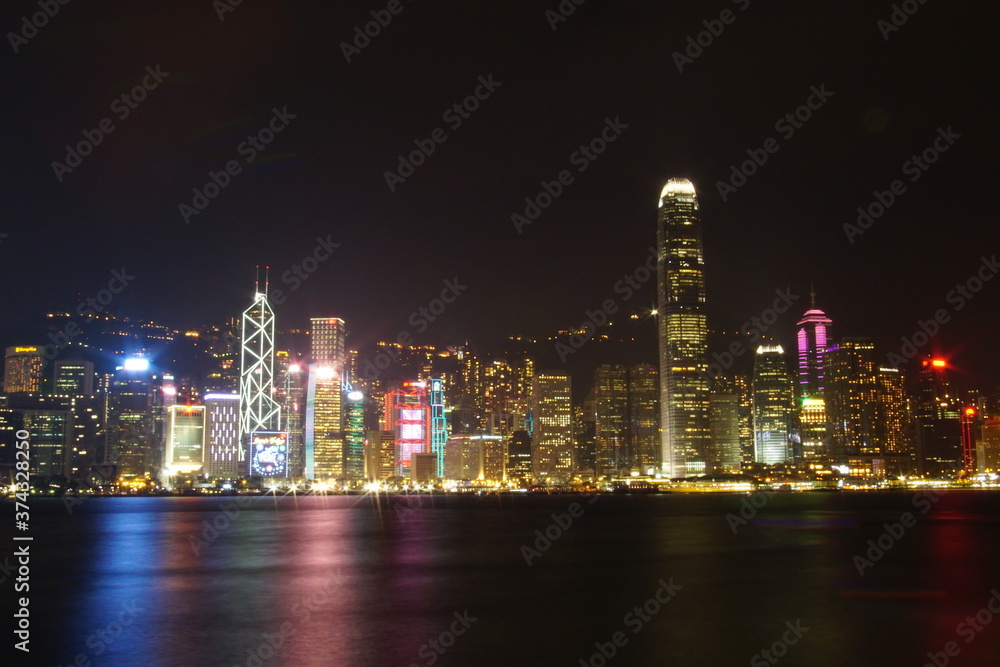 City landscape. Victoria Harbor and Hong Kong skyscrapers at night.