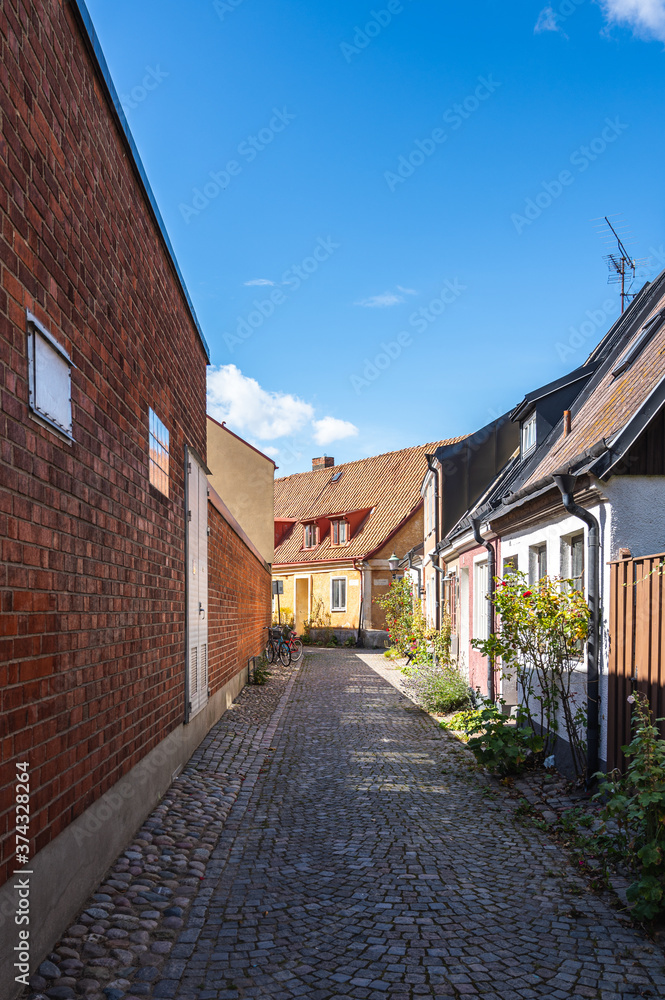 An empty cozy cobblestoned street with town houses and cottages in the village of Ystad, Sweden