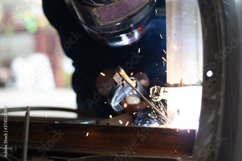Worker,welding in a car factory with sparks, manufacturing, industry