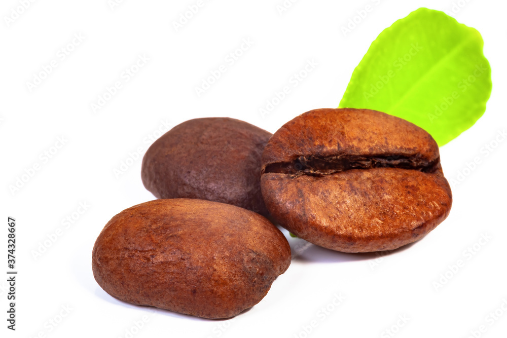 three roasted coffee beans and a green leaf on a white background, isolate three roasted coffee beans and a green leaf on a white background, isolate