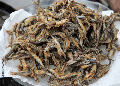 Anchovies are fried in vegetable oil in a pan.