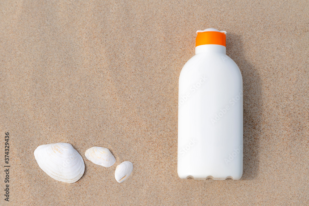 Sunscreen protection lotion in the sand on a sunny day at the beach. White sunblock cream protection bottle from sunburn. Nobody. Sunscreen protection lotion in the sand on a sunny day at the beach. White sunblock cream protection bottle from sunburn. Nobody.
