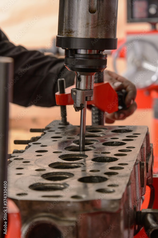 A craftsman sets up a machine for grinding car valves