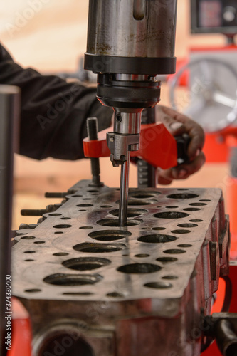 A craftsman sets up a machine for grinding car valves