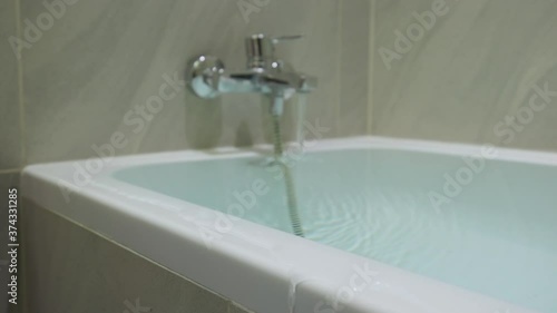 Flood in the bathroom, water is poured from the bathtub