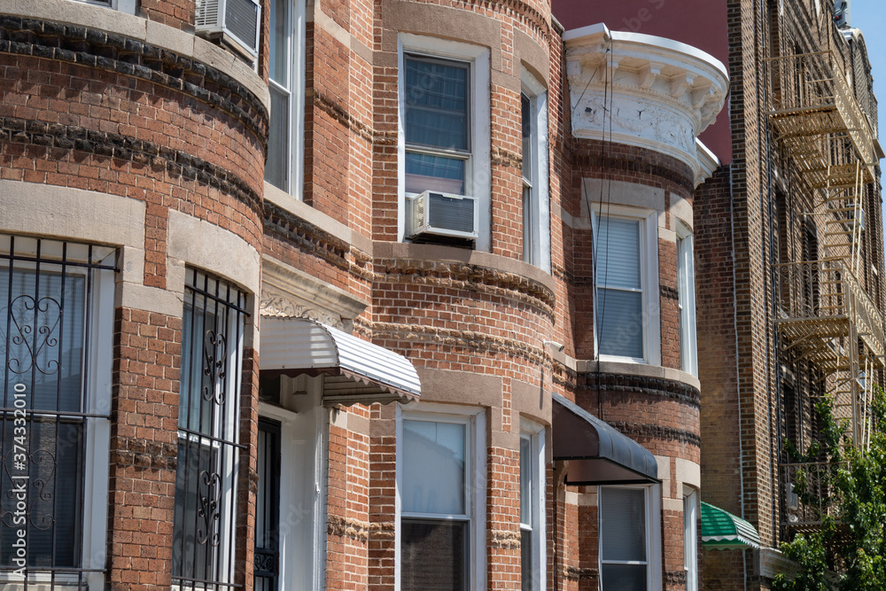 Naklejka premium Row of Old Brownstone Homes and Residential Buildings in Astoria Queens New York