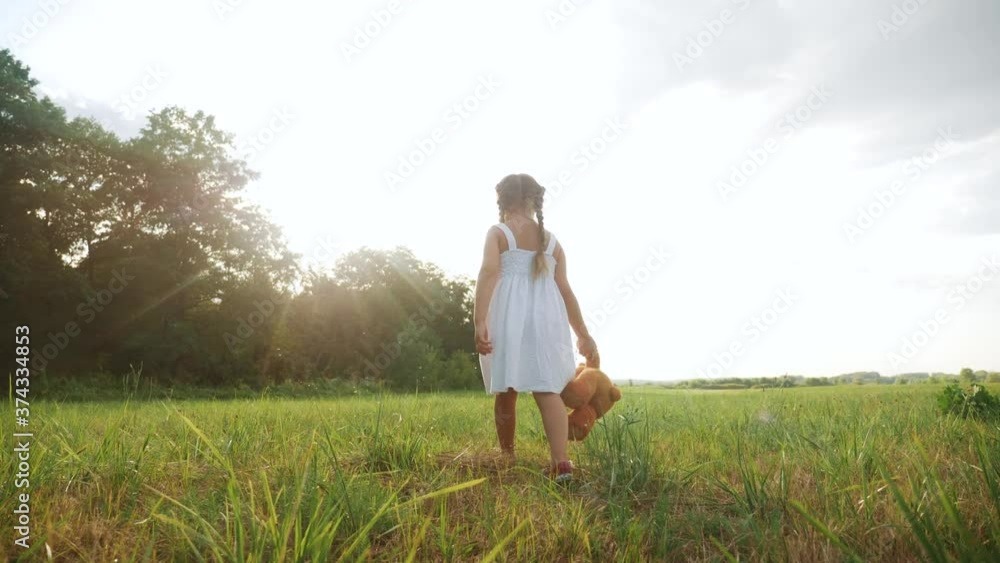 little kid girl walk with a teddy bear toy in the park in nature. childhood dream concept. smiling kid child walk with favorite toy teddy bear dream of happiness in a green lifestyle park outdoor little kid girl walk with a teddy bear toy in the park in nature. childhood dream concept. smiling kid child walk with favorite toy teddy bear dream of happiness in a green lifestyle park outdoor