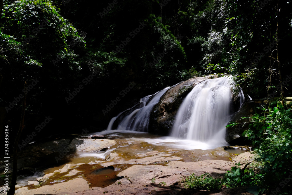 Obraz premium Beautiful waterfall in the forest wallpaper background