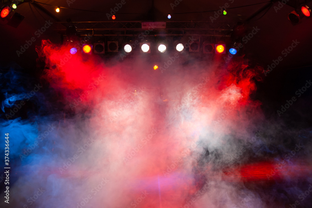 Stage in the dark with stage fog and red, blue and white spotlights