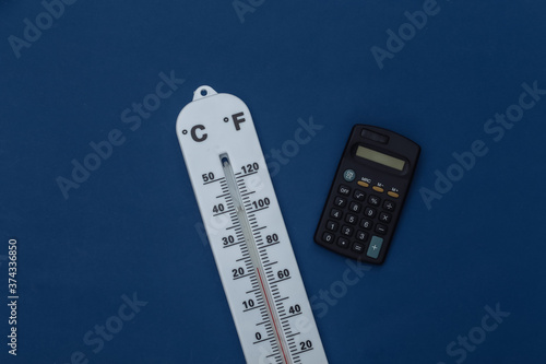 Weather thermometer and calculator on classic blue background. Color 2020. Tiop view photo