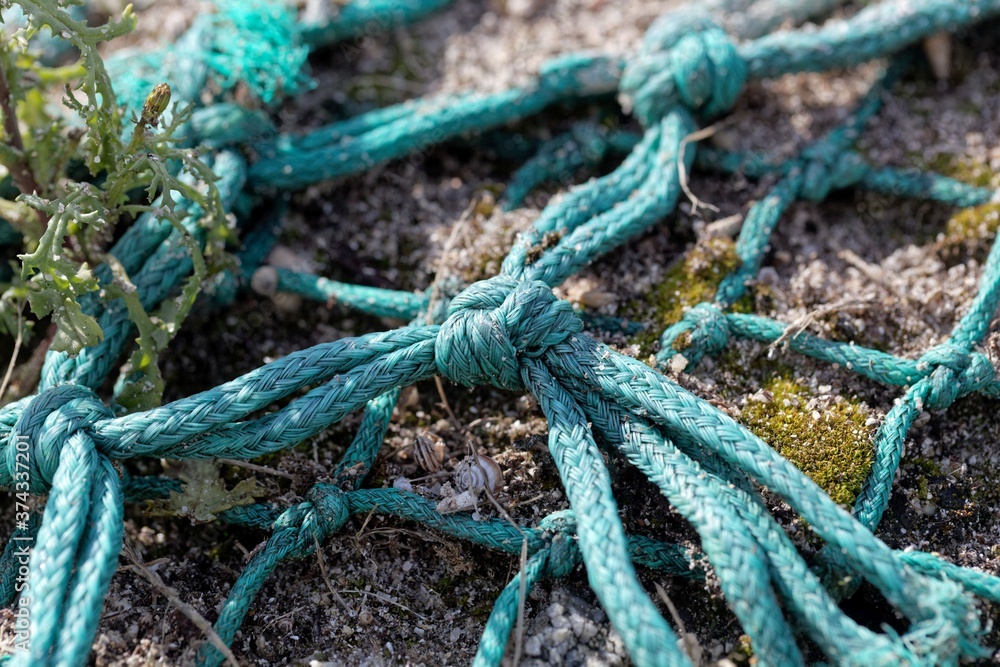 Detail of an old, blue fishing net on a beach
