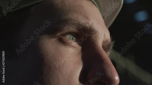 An engineer, builder, manager puts a white helmet on his head at sunset and looks into the distance. Inspired, focused gaze, blue eyes, innovative, new architectural, building project of the future.