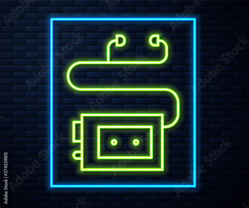 Glowing neon line Museum audio guide icon isolated on brick wall background. Headphones for excursions. Vector.