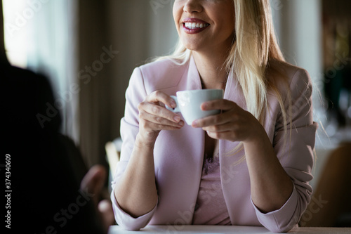 Beautiful businesswoman dressed in the suit drinking coffee. Businesswoman enjoying in the restaurant..
