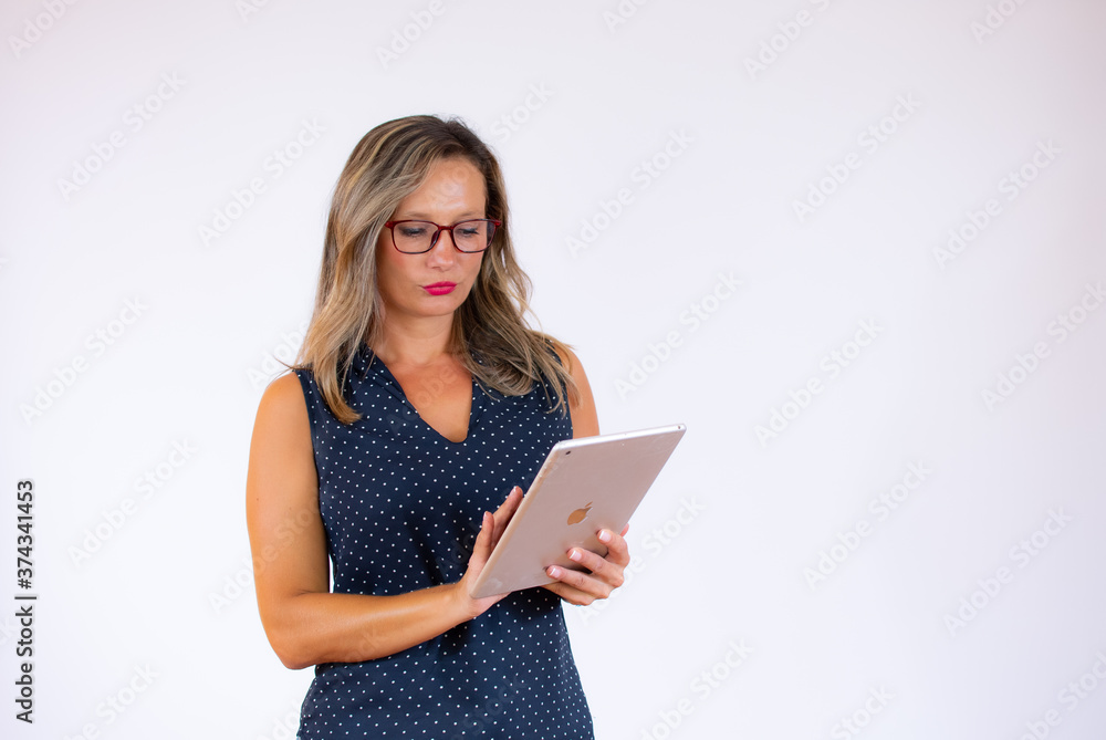 Woman in blue shirt thoughtful with tablet Woman in blue shirt thoughtful with tablet