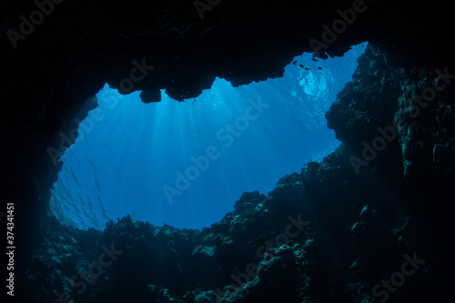 Sunlight filters into a dark, underwater cave in the Republic of Palau. Palau's spectacular and diverse coral reefs are riddled with caves, caverns, and blue holes. © ead72