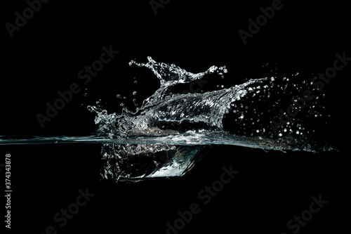 close up of water waves splash and bubbles isolated on black background.