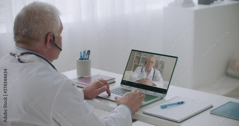two male doctors are talking by video calling, consulting and exchanging information and experience of curing two male doctors are talking by video calling, consulting and exchanging information and experience of curing