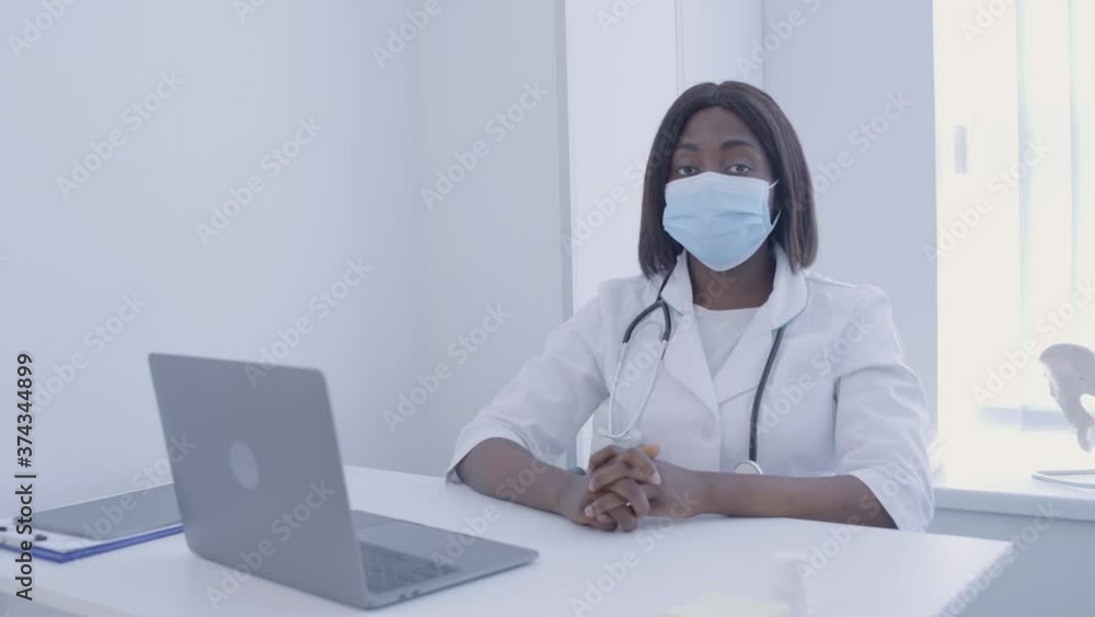 Therapist wearing mask sitting at the table in office, prevention of disease Therapist wearing mask sitting at the table in office, prevention of disease