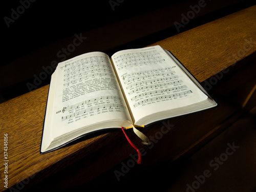 Gesangbuch liegt auf der Kirchenbank.