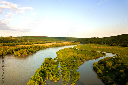 Obraz na plátně Aerial view of bright river flowing through green meadows in spring