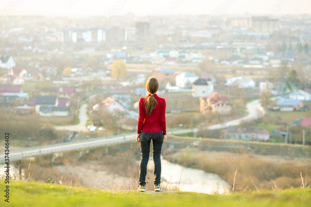 Young woman standing outdoors enjoying city view. Relaxing, freedom and wellness concept. Young woman standing outdoors enjoying city view. Relaxing, freedom and wellness concept.