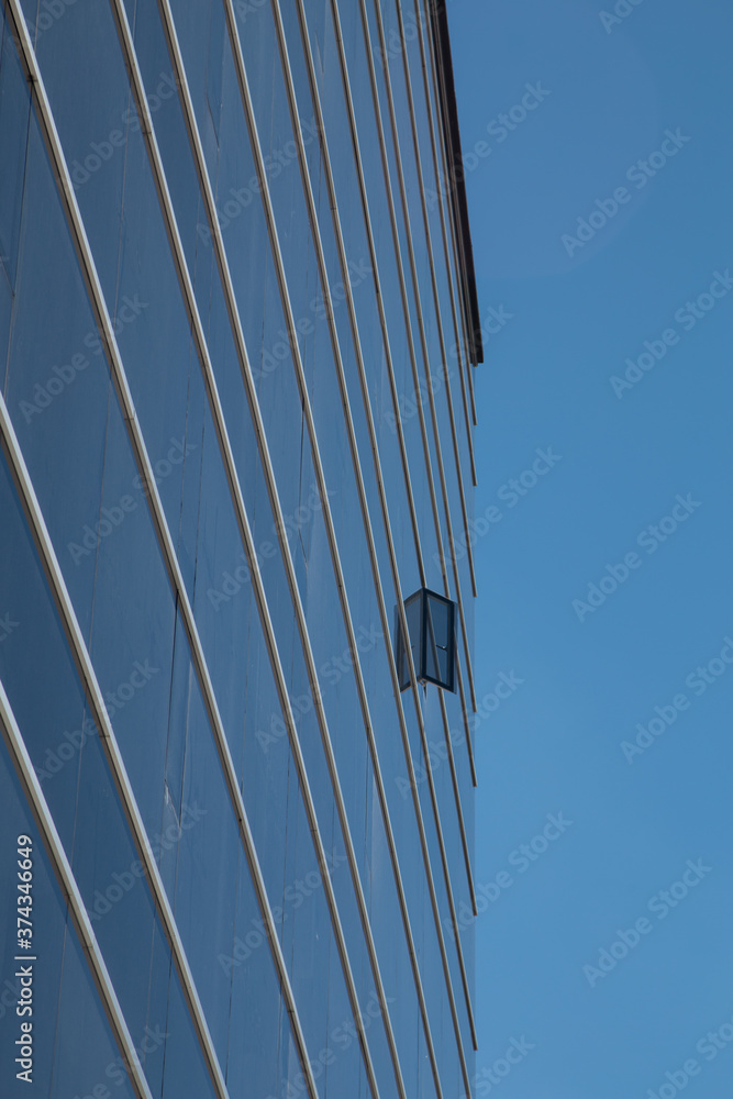 blue glass building with an open window, photo taken from up close and ...