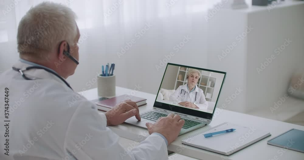 two medical specialists are chatting online by web camera, consulting and exchanging information two medical specialists are chatting online by web camera, consulting and exchanging information