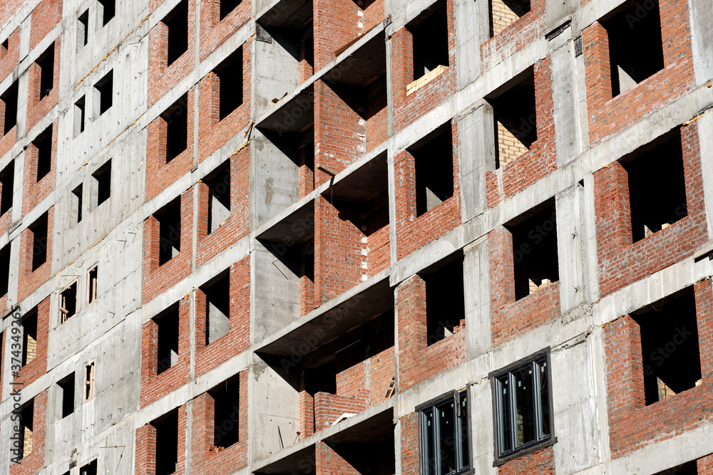 Detail of residential building under construction. Concrete structure with metal struts and temporary wooden railings. High-rise residential building under construction Detail of residential building under construction. Concrete structure with metal struts and temporary wooden railings. High-rise residential building under construction