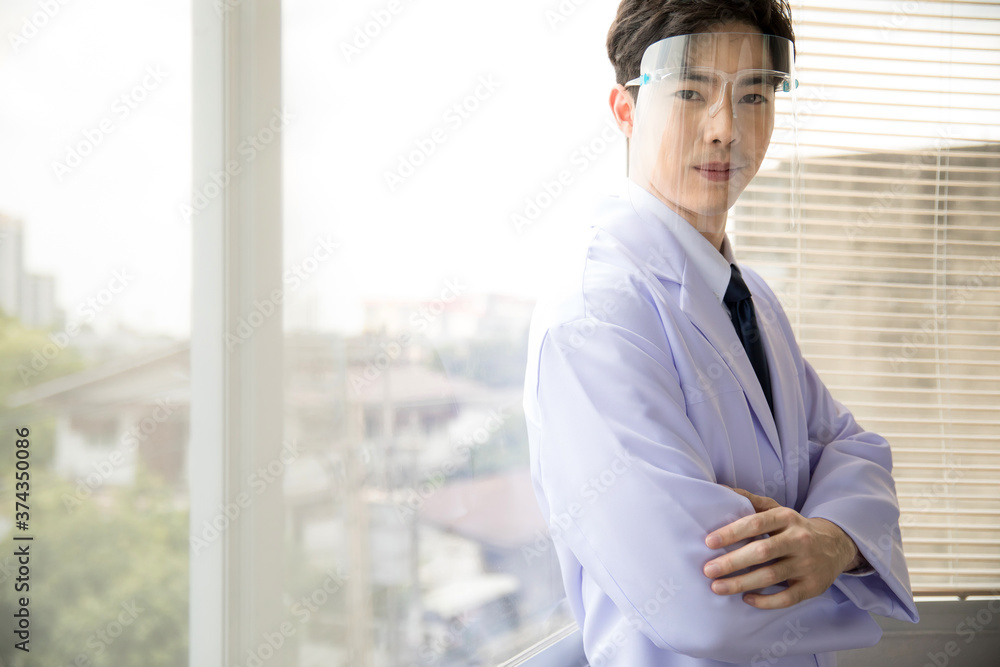 portrait of a confident male doctor standing by the window portrait of a confident male doctor standing by the window