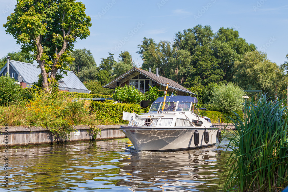 Fototapeta premium Motorboat entering Paterswoldsemeer a lake near Groningen in the Netherlands on a summer day