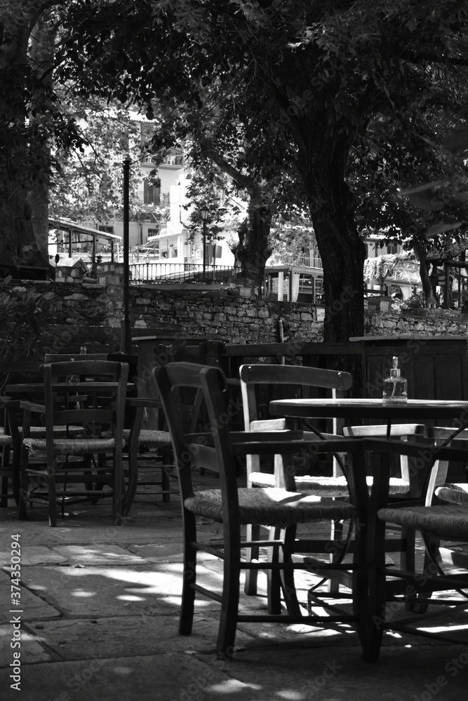 table and chairs in a cafe (in the central square of a village) (black & white)