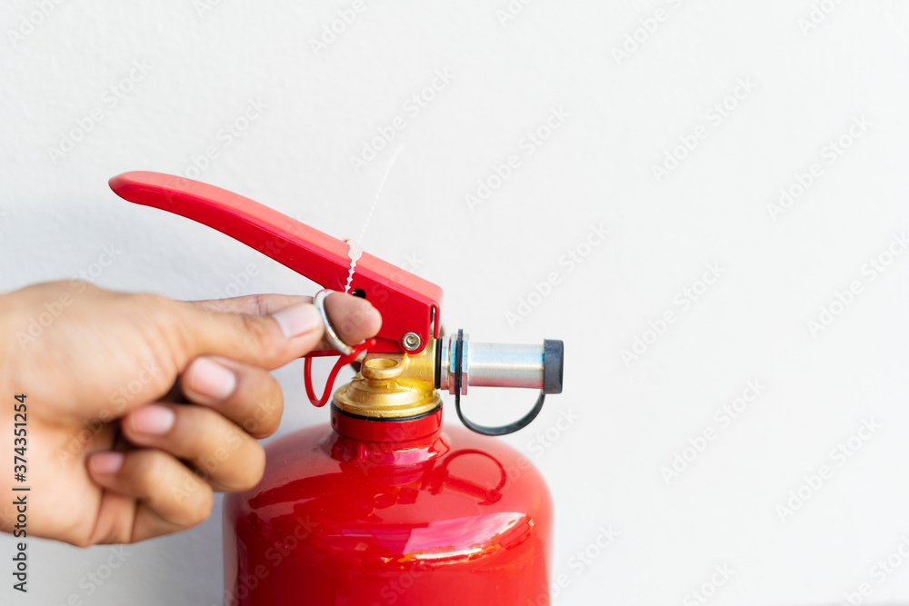 Man hand pressing fire extinguisher on white background and copy space.