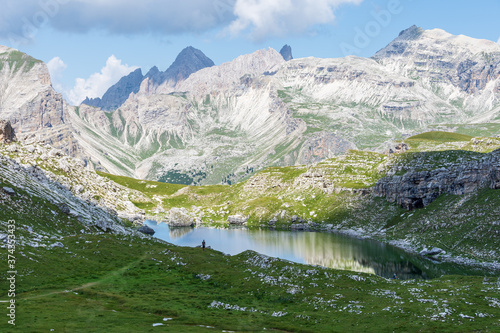 Panoramic view over Crespeina Lake, a pristine Alpine lake located at an altitude of 2300m (7500ft) in the Puez-Odle mountain range in a cloudy summer day. South Tyrol, Italy