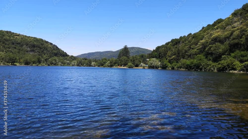 Landscape of a mountain lake with blue water against a blue sky Landscape of a mountain lake with blue water against a blue sky