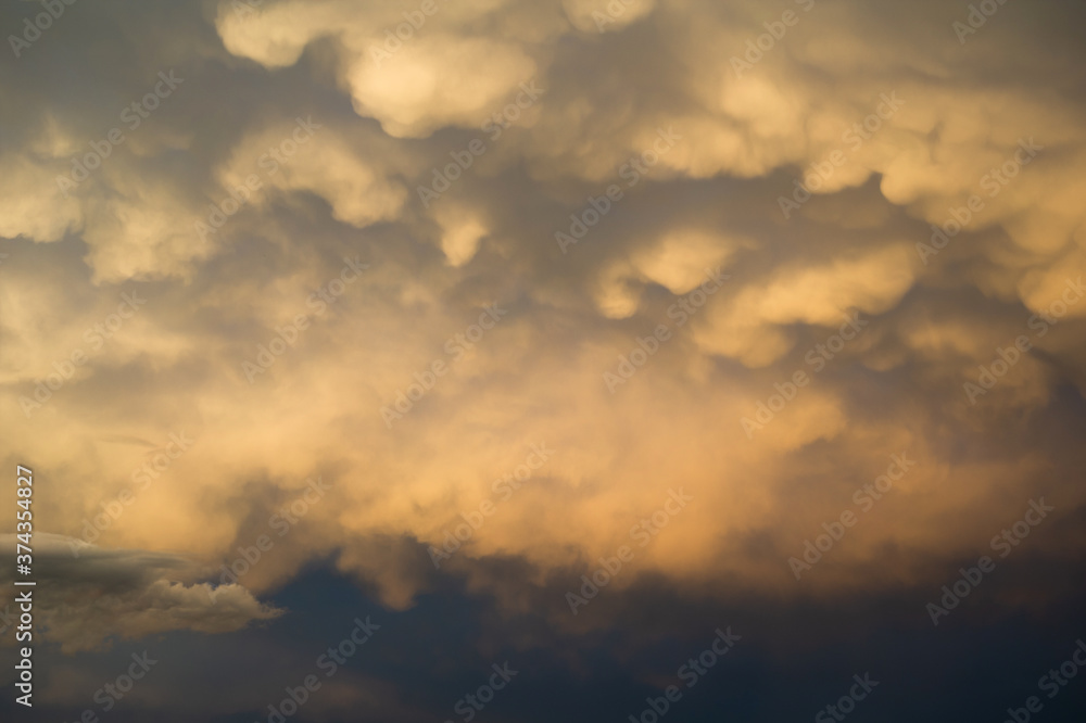 Clouds in the evening - yellow and orange sunset light lit cloud. Beautiful nature, landscape and cloudscape scenery. Very soft abstract style. Warm yellow and orange color. Clouds in the evening - yellow and orange sunset light lit cloud. Beautiful nature, landscape and cloudscape scenery. Very soft abstract style. Warm yellow and orange color.