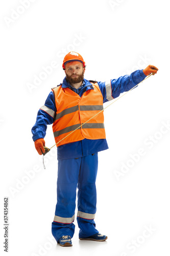 Handsome contractor, builder in face mask isolated over white studio background. Concept of professional occupation, work, job, building, investment. Copyspace for ad, text. Caucasian man wearing