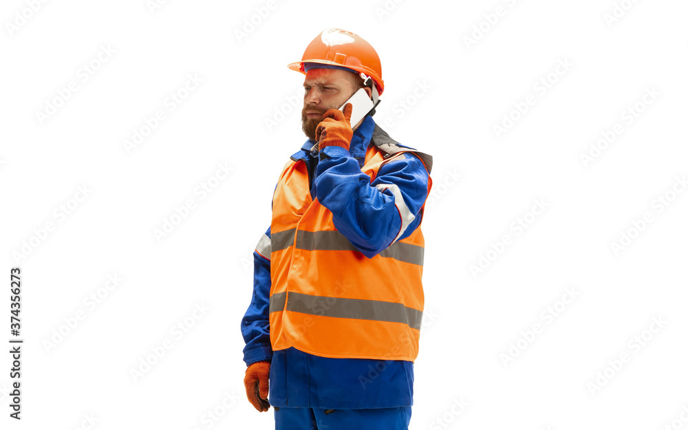 Using device, gadget. Handsome contractor, builder isolated on white background. Concept of professional occupation, work, job, building, investment. Copyspace for ad, text. Caucasian man wearing Using device, gadget. Handsome contractor, builder isolated on white background. Concept of professional occupation, work, job, building, investment. Copyspace for ad, text. Caucasian man wearing