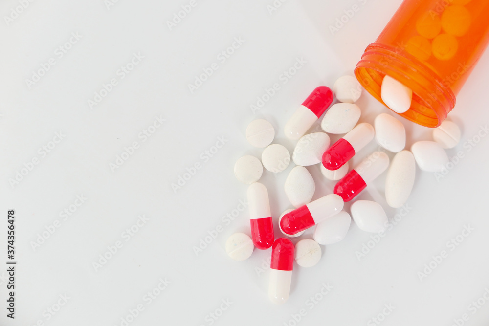 close up of colorful pills spilling on white background close up of colorful pills spilling on white background