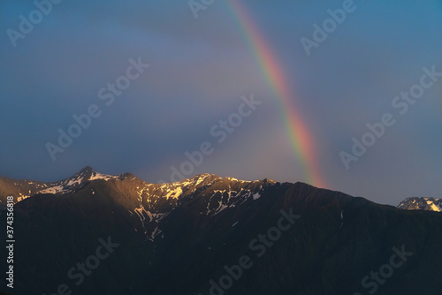 Rainbow over Austrian alp mountains during last sun rays of sunset, Mieminger Plateau, Tyrol, Austria