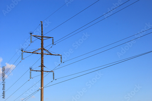 Power pole and power lines against the blue sky