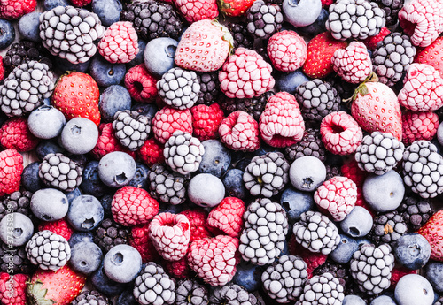 Berries fruits with frost, frozen berries background.