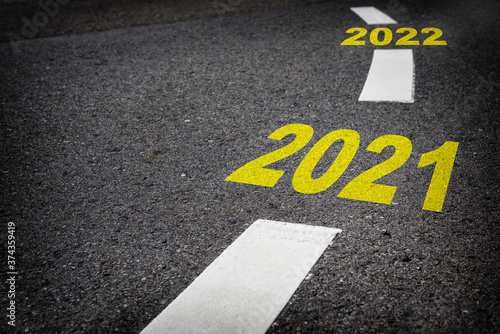 Close up new year 2021 to 2022 on black asphalt road and white marking lines, Happy new year and road to success concept