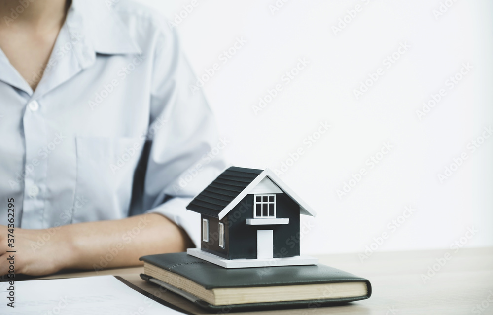 Home model standing in front of a real estate agent explain the business contract, rent, buy, mortgage, loan, or home insurance to the buyer Home model standing in front of a real estate agent explain the business contract, rent, buy, mortgage, loan, or home insurance to the buyer