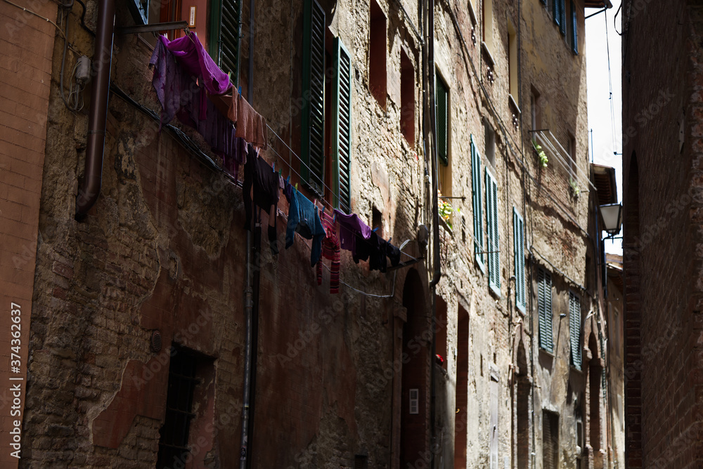 Old buildings inside one of the alleys of the town of Siena